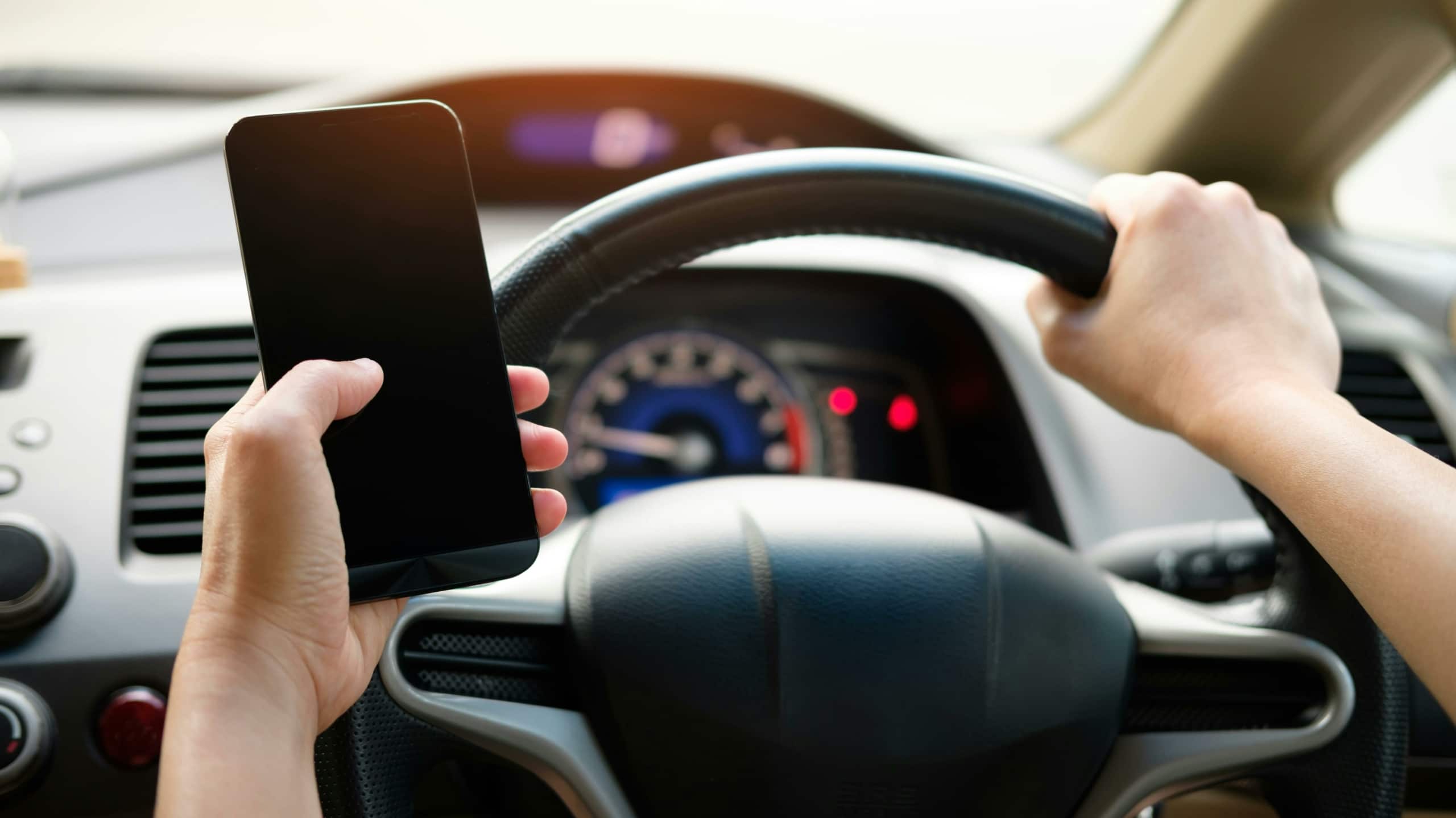 someone holding a smartphone while driving